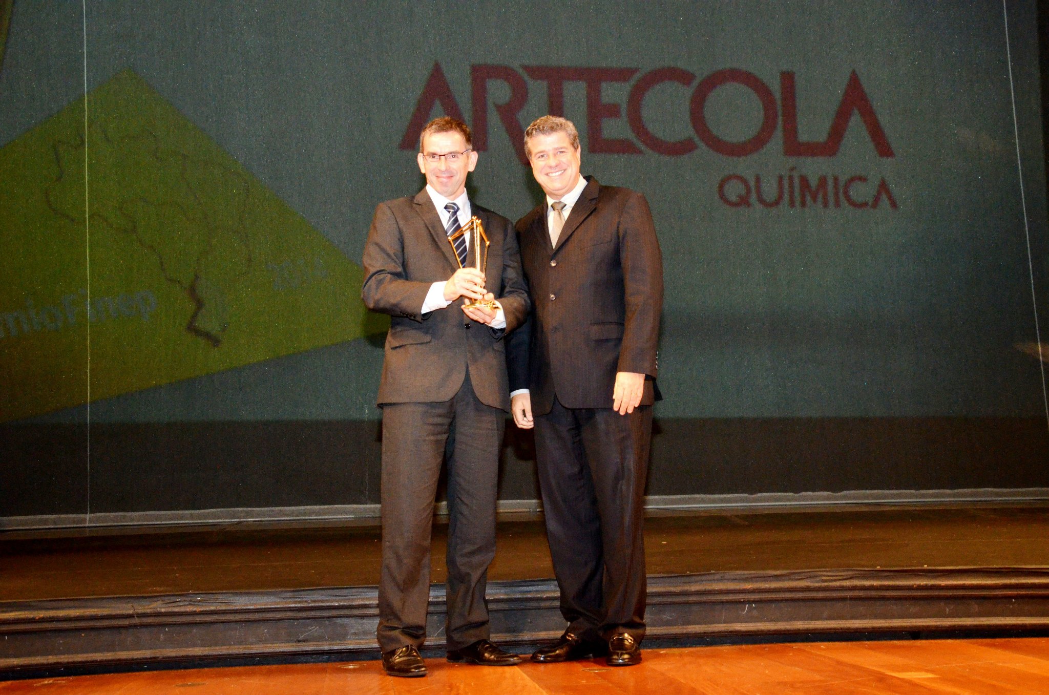 Claudio Guimarães entrega troféu a  Nei Sebastião representante da Artecola Química.