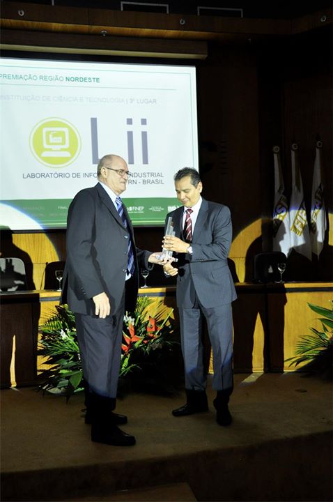 Luiz Henderson Guedes de Oliveira, do Laboratório de Informática Industrial da Universidade Federal do Rio Grande do Norte, terceiro lugar na categoria ICT, recebe troféu de o diretor presidente do Parque de Desenvolvimento Tecnológico - PADETEC -, Afrânio Aragão Craveiro.