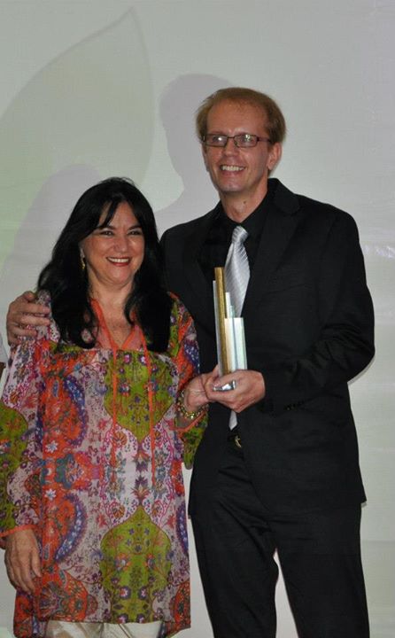 Herve Loius Ghislain Rogez, da Amazon Dreams, vencedora na categoria Pequena Empresa, recebe troféu da diretora da Chama da Amazônia, Maria de Fátima Chama.